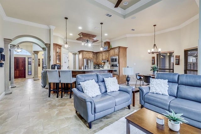 4530 Ballad Tree Dr, Corpus Christi, TX 78410 - living room with decorative columns, baseboards, arched walkways, crown molding, and a chandelier