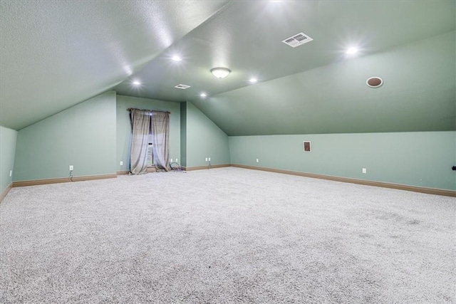 4530 Ballad Tree Dr, Corpus Christi, TX 78410 - additional living space with vaulted ceiling, carpet flooring, baseboards, and a textured ceiling