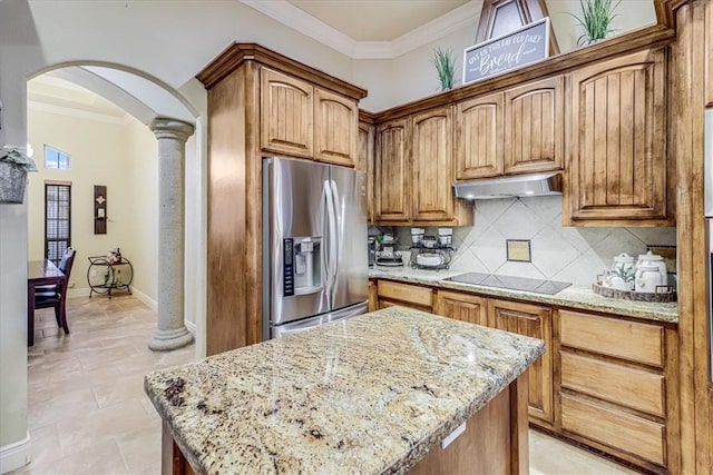4530 Ballad Tree Dr, Corpus Christi, TX 78410 - kitchen with stainless steel refrigerator with ice dispenser, under cabinet range hood, arched walkways, black electric cooktop, and light stone counters