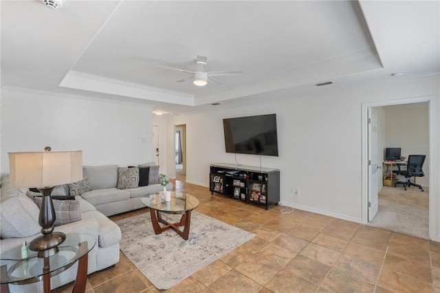 living room featuring a raised ceiling, ornamental molding, and ceiling fan