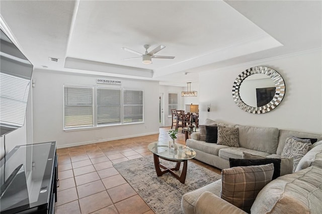 living room featuring light tile patterned floors, a raised ceiling, and ceiling fan