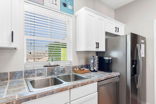 kitchen featuring stainless steel appliances, a sink, and white cabinets