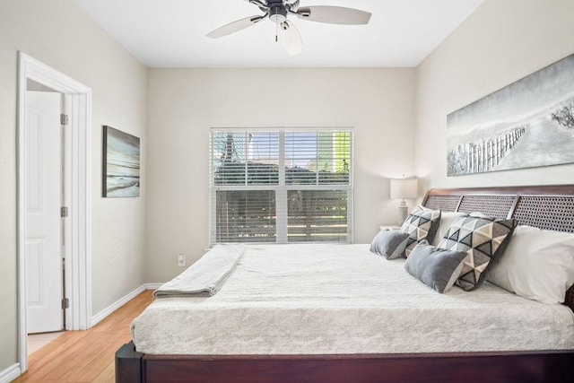 bedroom featuring ceiling fan, baseboards, and wood finished floors