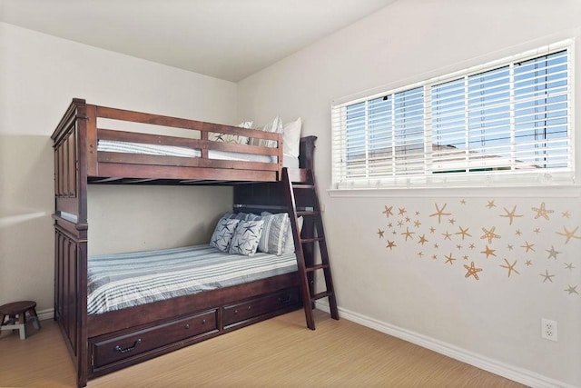 bedroom with light wood-type flooring and baseboards