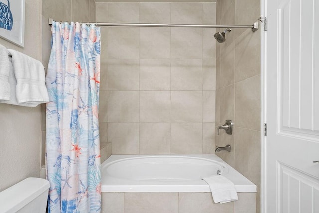 full bathroom with tiled shower / bath combo and toilet