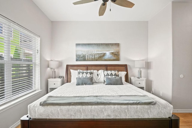 bedroom with a ceiling fan, baseboards, and wood finished floors