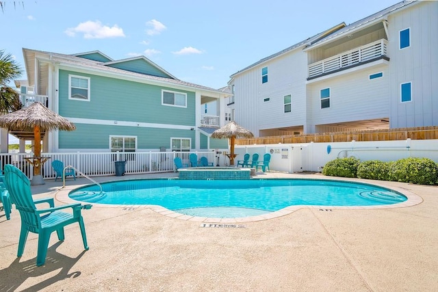 pool with a patio and fence