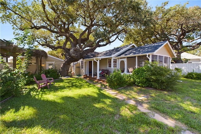 view of front of home featuring a sunroom and a front yard