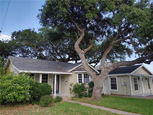 single story home with covered porch and a front yard