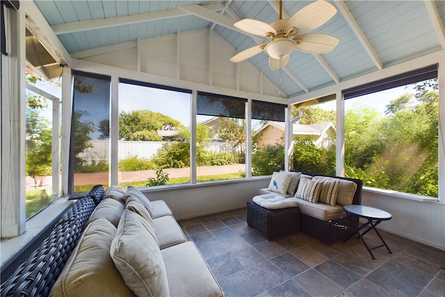 sunroom with lofted ceiling with beams, ceiling fan, and a wealth of natural light