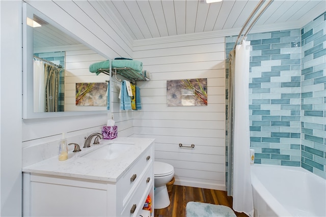 full bathroom featuring vanity, shower / bath combo with shower curtain, wooden walls, hardwood / wood-style flooring, and toilet