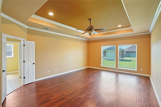 empty room featuring ceiling fan, a raised ceiling, crown molding, and wood-type flooring