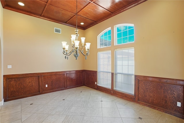 unfurnished room featuring ornamental molding, a notable chandelier, and wood ceiling