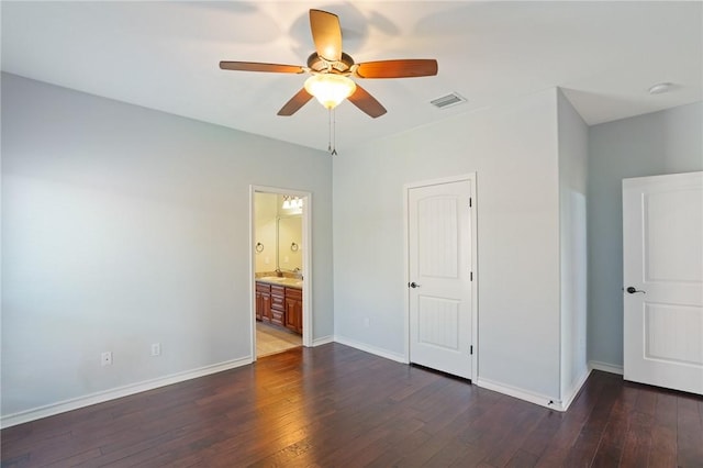 unfurnished bedroom featuring dark wood-type flooring, ensuite bath, and ceiling fan