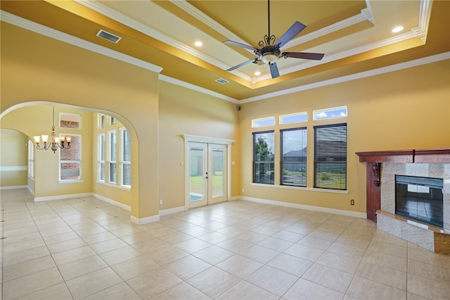 unfurnished living room with light tile patterned flooring, a tray ceiling, and ornamental molding