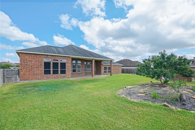 rear view of property featuring a yard