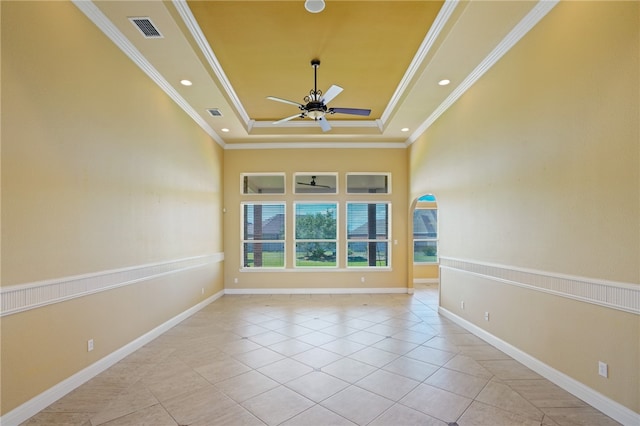 unfurnished room with crown molding, light tile patterned floors, ceiling fan, and a raised ceiling