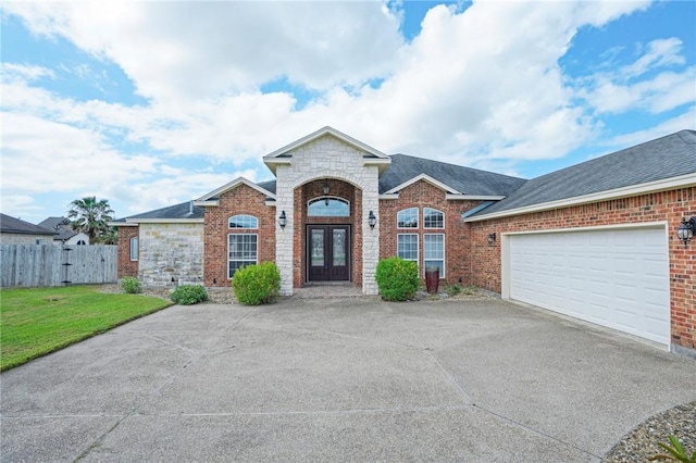 view of front facade with a garage, a front lawn, and french doors