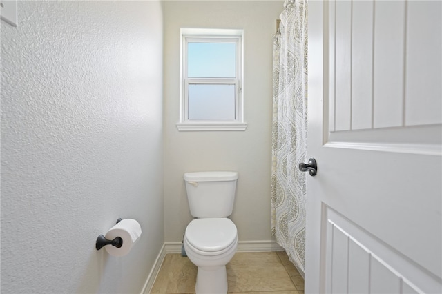 bathroom with toilet and tile patterned flooring