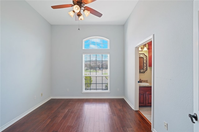 unfurnished room featuring dark wood-type flooring, sink, and ceiling fan