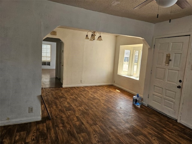 entrance foyer featuring wood finished floors, arched walkways, and baseboards