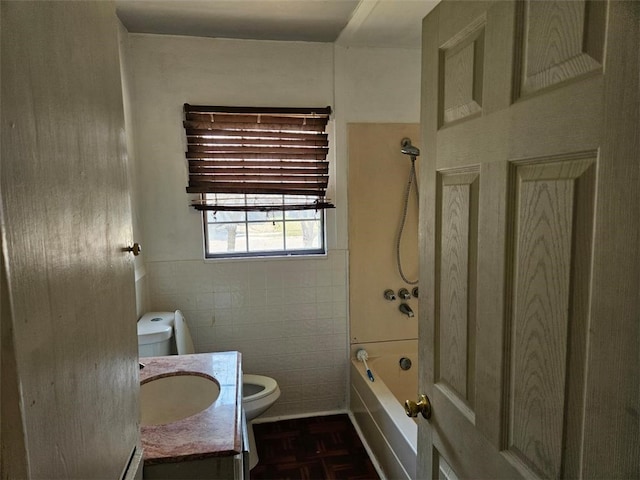 bathroom featuring tile walls, toilet, vanity, and shower / bathing tub combination