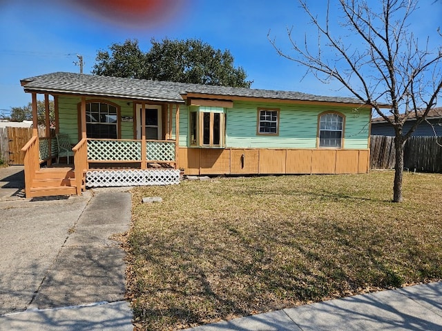 ranch-style home featuring a porch, a front lawn, and fence