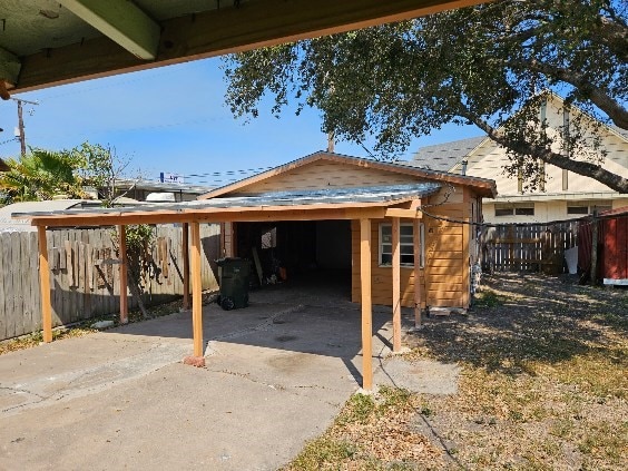 view of patio featuring a carport and fence