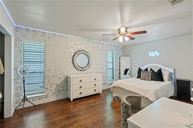 6205 Londonderry Dr, Corpus Christi, TX 78415 - bedroom with dark wood-style floors, wallpapered walls, ceiling fan, and a textured ceiling