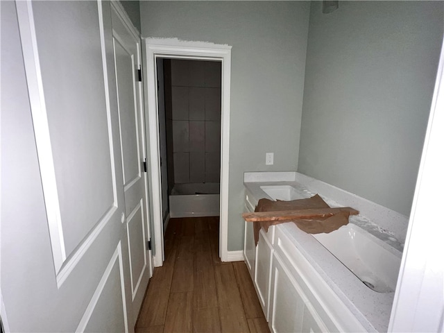 bathroom with vanity, hardwood / wood-style flooring, and a bathing tub