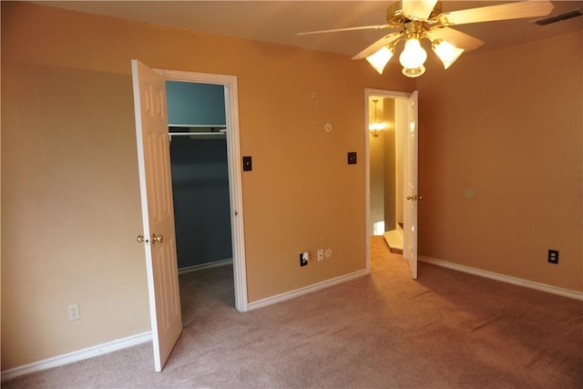 unfurnished bedroom featuring a closet, visible vents, baseboards, carpet floors, and a spacious closet