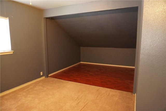 additional living space featuring carpet flooring, baseboards, and lofted ceiling