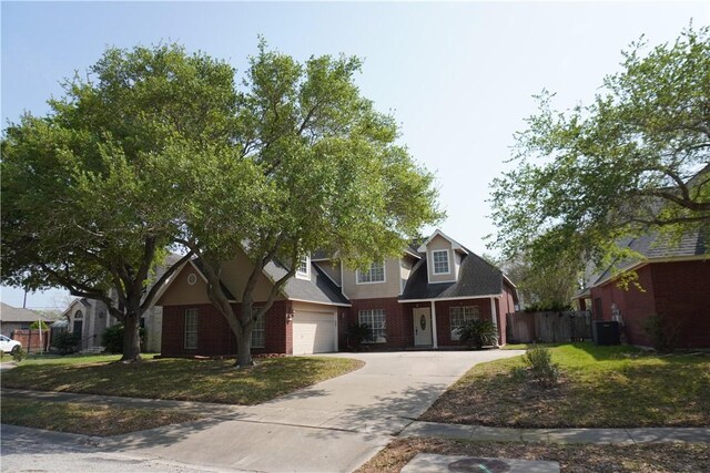 view of front facade with driveway, a front yard, fence, brick siding, and a garage