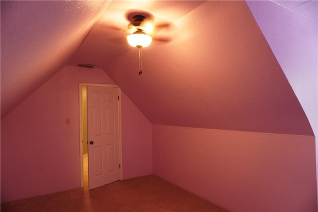 bonus room featuring carpet floors, a textured ceiling, lofted ceiling, and visible vents