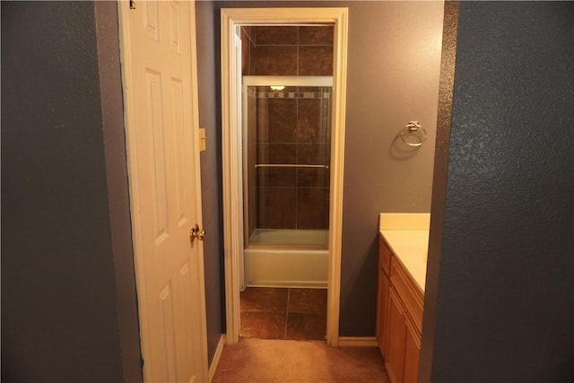 full bath with enclosed tub / shower combo, tile patterned flooring, and vanity