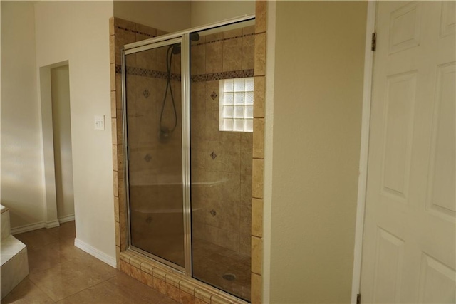 full bathroom featuring a stall shower, tile patterned floors, and baseboards
