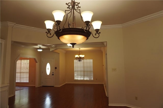 foyer entrance with a notable chandelier, wood finished floors, arched walkways, and ornamental molding