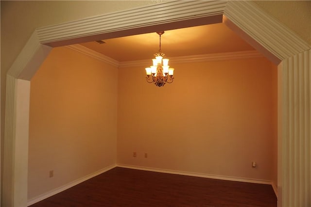 unfurnished room featuring dark wood-type flooring, baseboards, a chandelier, and crown molding