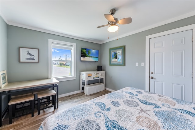 bedroom with hardwood / wood-style floors, ceiling fan, and crown molding