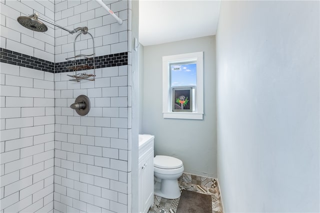 bathroom with vanity, toilet, and a tile shower