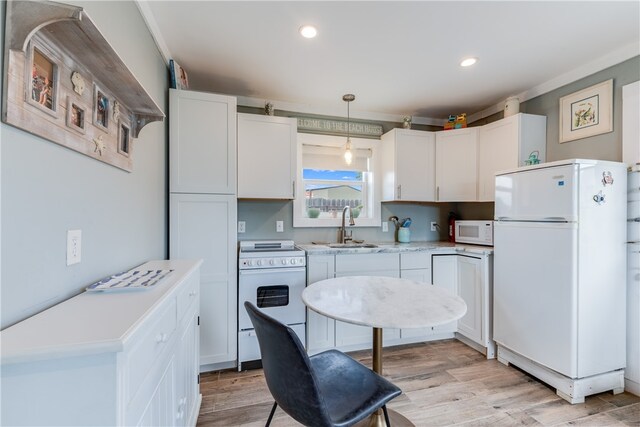 kitchen featuring sink, white cabinetry, white appliances, and decorative light fixtures