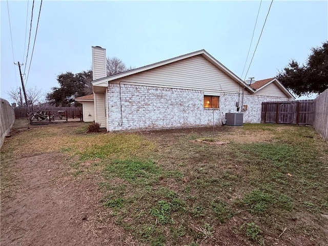 view of side of home with a yard and central AC unit