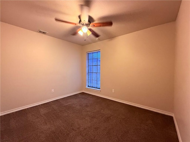 unfurnished room featuring dark carpet and ceiling fan