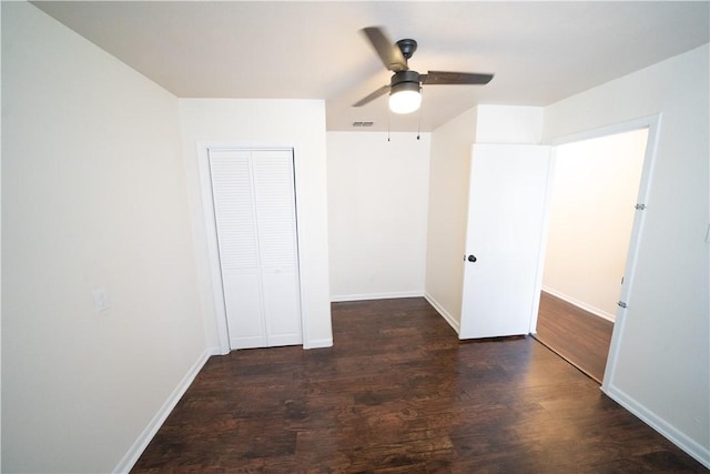 unfurnished bedroom with a closet, ceiling fan, and dark wood-type flooring