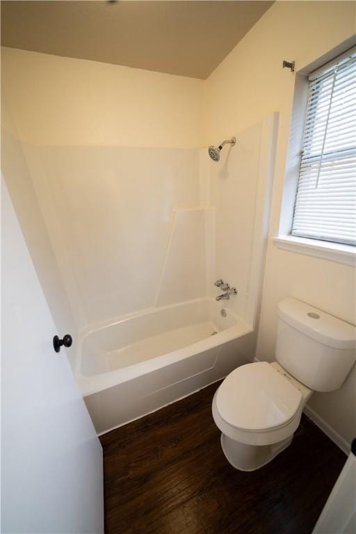 bathroom with hardwood / wood-style floors, shower / bathtub combination, and toilet