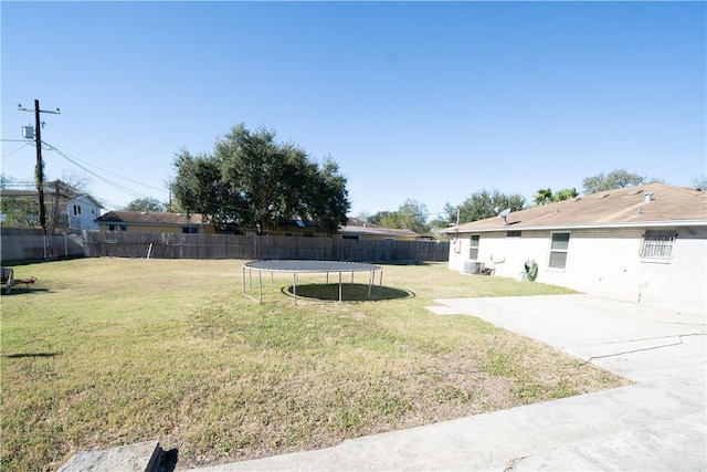 view of yard with cooling unit, a trampoline, and a patio