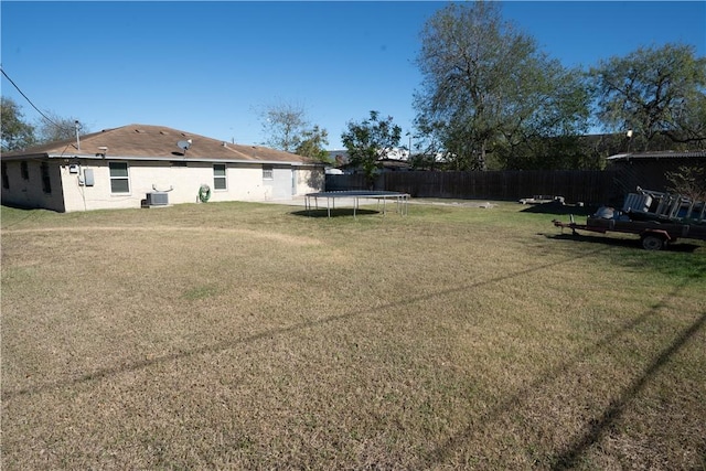 view of yard featuring a trampoline and central air condition unit