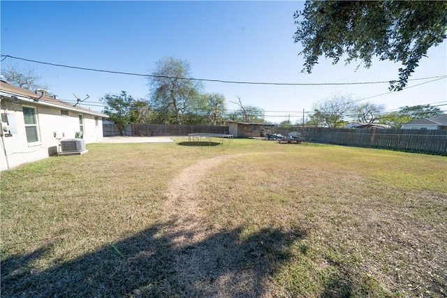 view of yard featuring a trampoline and central air condition unit