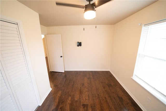 empty room featuring dark hardwood / wood-style flooring, plenty of natural light, and ceiling fan