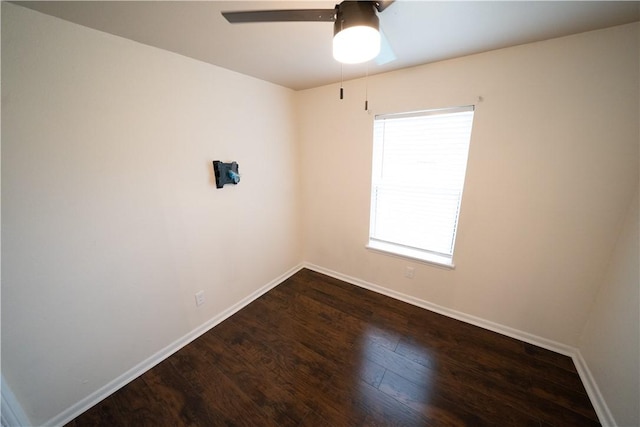 spare room featuring dark hardwood / wood-style floors, ceiling fan, and a wealth of natural light